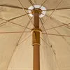 Close-up view of the internal mechanism and fabric of a tan umbrella. Voir les images du produit