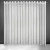 A white sheer curtain hanging on a rod against a dark gray wall. Voir les images du produit