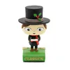 A figurine of a boy in a top hat holding a candle, standing on a green book with the word 'CLASSICS' on it. Produktbild-Vorschau