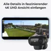 A smartphone displaying a video feed of an outdoor area with a golf putting green and a security camera in the foreground. Produktbild-Vorschau