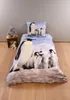 A duvet cover and pillow set with a penguin design is laid out on a wooden floor against a light gray wall. A teddy bear and two small stuffed animals are placed on a wooden crate to the left. Náhľad obrázku produktu