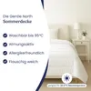 A white duvet is laid on a bed in a bedroom setting, with text overlays describing its features. Produktbild-Vorschau