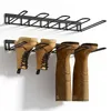 Two black metal boot racks mounted on a white wall, with pairs of boots hanging from them. Produktbild-Vorschau