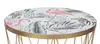 A close-up of a round side table with a tropical print on the tabletop. Produktbild-Vorschau