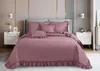 A bed with a pink quilted comforter and pillows in a bedroom setting. Produktbild-Vorschau