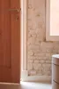 A close-up view of a wooden door and a brick wall with a white trim, suggesting an interior setting. Produktbild-Vorschau