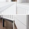 Collage of close-up shots of a white dresser or cabinet, highlighting its textured doors and drawer fronts, and its black legs. Voir les images du produit