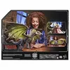 A young girl is excitedly holding a dragon toy in front of a box that displays the Dungeons & Dragons logo and other product images. Produktbild-Vorschau
