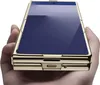 A hand holding a gold smartphone with a blue screen. Produktbild-Vorschau