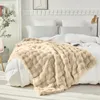 A plush blanket is draped over a bed with white bedding. Produktbild-Vorschau