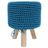 A blue crocheted pouf with wooden legs against a white background. Náhled obrázku produktu