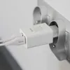A white Vayox charger with two USB ports is plugged into a wall socket. Produktbild-Vorschau