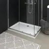 A modern bathroom scene featuring a white shower tray with a textured surface, enclosed by glass panels. Produktbild-Vorschau