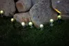 Small garden lights illuminating grass and rocks at night. Produktbild-Vorschau