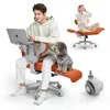 A man is working on a laptop while sitting in an orange office chair, with a dog sitting on the chair next to him. Another person is seen in the background relaxing in a similar chair. Produktbild-Vorschau