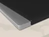 Close-up of the edge of a black induction hob with a silver frame, resting on a light-colored countertop. Anteprima dell’immagine prodotto