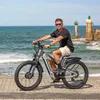 A man rides an electric bicycle on a paved path near the ocean, with lighthouses in the background. Produktbild-Vorschau