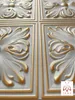 A close-up view of decorative wall or ceiling panels with a floral motif, featuring a white base with gold accents. Produktbild-Vorschau