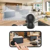 A split image showing a security camera in a living room and a smartphone displaying a live feed of a kitchen. Produktbild-Vorschau