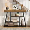 A console table with decorative items placed on it, situated in a hallway next to a staircase. Náhled obrázku produktu