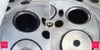 A split image showing a comparison of engine cylinder heads before and after cleaning. Produktbild-Vorschau