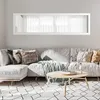 A living room scene with a sectional sofa, coffee table, and a long mirror above the sofa. Produktbild-Vorschau