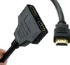 A hand holding a black HDMI splitter cable with two female HDMI ports and one male HDMI connector. Náhled obrázku produktu