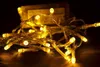 A close-up shot of a string of warm white LED lights coiled on a dark surface. Produktbild-Vorschau