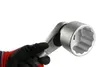 A gloved hand holding a large socket wrench. Produktbild-Vorschau