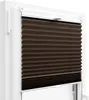 A close-up view of a brown pleated blind installed in a white window frame. Náhled obrázku produktu