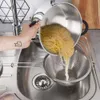 A hand is pouring spaghetti from a pot into a colander in a kitchen sink. Náhľad obrázku produktu