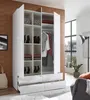 A white, three-door wardrobe with open doors, revealing shelves and hanging clothes. The wardrobe is in a room with a brown textured wall and a large window. Produktbild-Vorschau