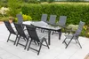 A patio set with a table and chairs on a tiled patio, surrounded by greenery. Produktbild-Vorschau