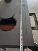 A close-up view of a black stove with a measuring tape placed vertically on its surface. Produktbild-Vorschau