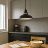 A kitchen scene with a pendant light, coffee maker, kettle, and a table with a notebook and bowl. Produktbild-Vorschau