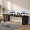 A long black desk with two computer monitors, keyboards, and books is set up in a modern office or home office environment with a plant and a chair. Produktbild-Vorschau