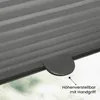 A close-up view of a gray pleated blind with a handle, set against a blurred background of green and white, suggesting an outdoor or sky view. Produktbild-Vorschau