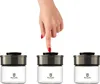 A hand is pressing the lid of one of three identical glass storage jars. Produktbild-Vorschau