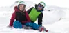 Two children in ski gear sitting in the snow. Voir les images du produit