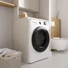 A modern laundry room with a washing machine, laundry basket, and toilet. Náhľad obrázku produktu