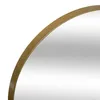 A close-up view of the edge of a round mirror with a gold metal frame. Podgląd zdjęcia produktu