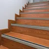 A close-up view of wooden stairs with gray trim and black anti-slip strips. Anteprima dell’immagine prodotto
