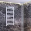A modern bathroom with dark marble walls, a white towel warmer, and a running shower. Náhled obrázku produktu