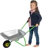 A young girl is pushing a toy wheelbarrow. Produktbild-Vorschau