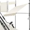 A cream-colored awning with a scalloped edge, supported by black poles, is shown in an extended position. Another awning is shown retracted in the background. A close-up detail of the awning's adjustable pole mechanism is also visible. Náhled obrázku produktu
