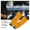A welder working with sparks flying, with a pair of leather sleeves in the foreground. Produktbild-Vorschau