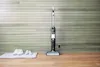 A vacuum cleaner and shoes are placed on a wooden floor in front of a wood-paneled wall. Voir les images du produit