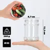 A hand holds a jar lid with vegetables, and another hand holds a glass jar with dimensions indicated. Náhled obrázku produktu