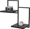 A black metal shelf unit with a camera on the top shelf and a baseball on the bottom shelf. Produktbild-Vorschau