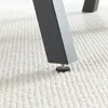 A close-up shot of the bottom of a table leg with an adjustable foot on a textured white carpet. Podgląd zdjęcia produktu